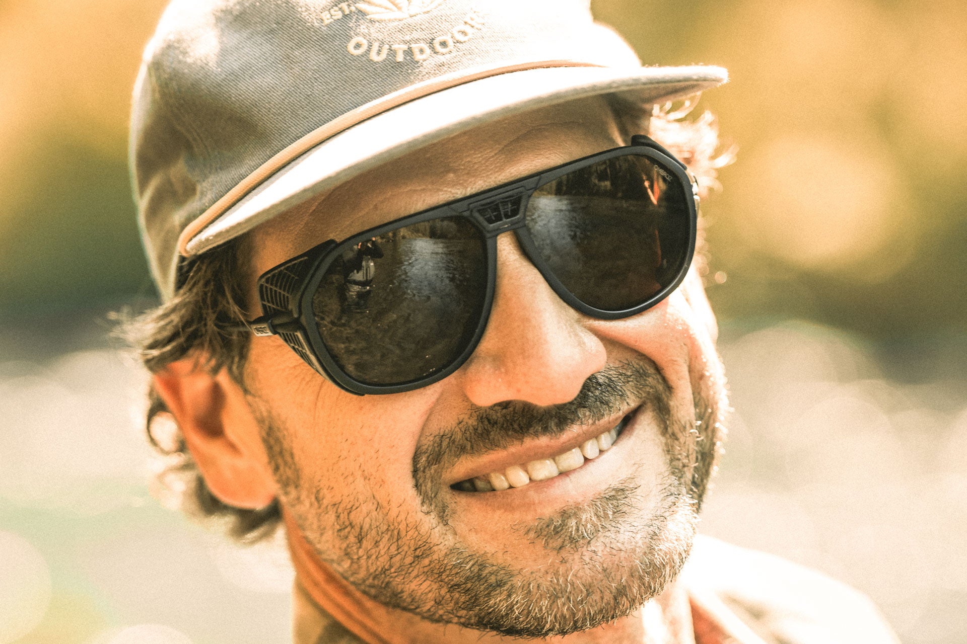 Portrait of a man smiling wearing Ombraz armless string sunglasses