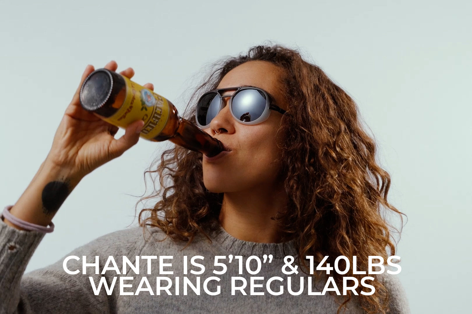 black_ice_silver_mirror_thumbnail_sizing Woman drinking a beer wearing Ombraz dolomite limited edition armless string sunglasses