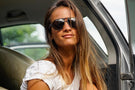 Tortoise_grey Woman in a car wearing Ombraz classic armless strap sunglasses
