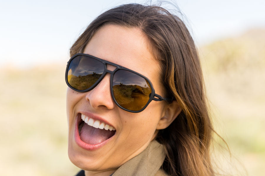 charcoal_yellow Smiling woman sporting Ombraz classic armless string sunglasses