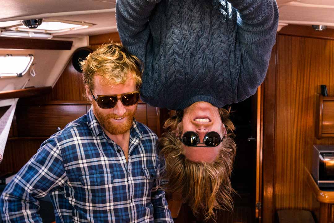 ember_grey Two guys, one hanging upside down, sporting Ombraz armless sunglasses with cord