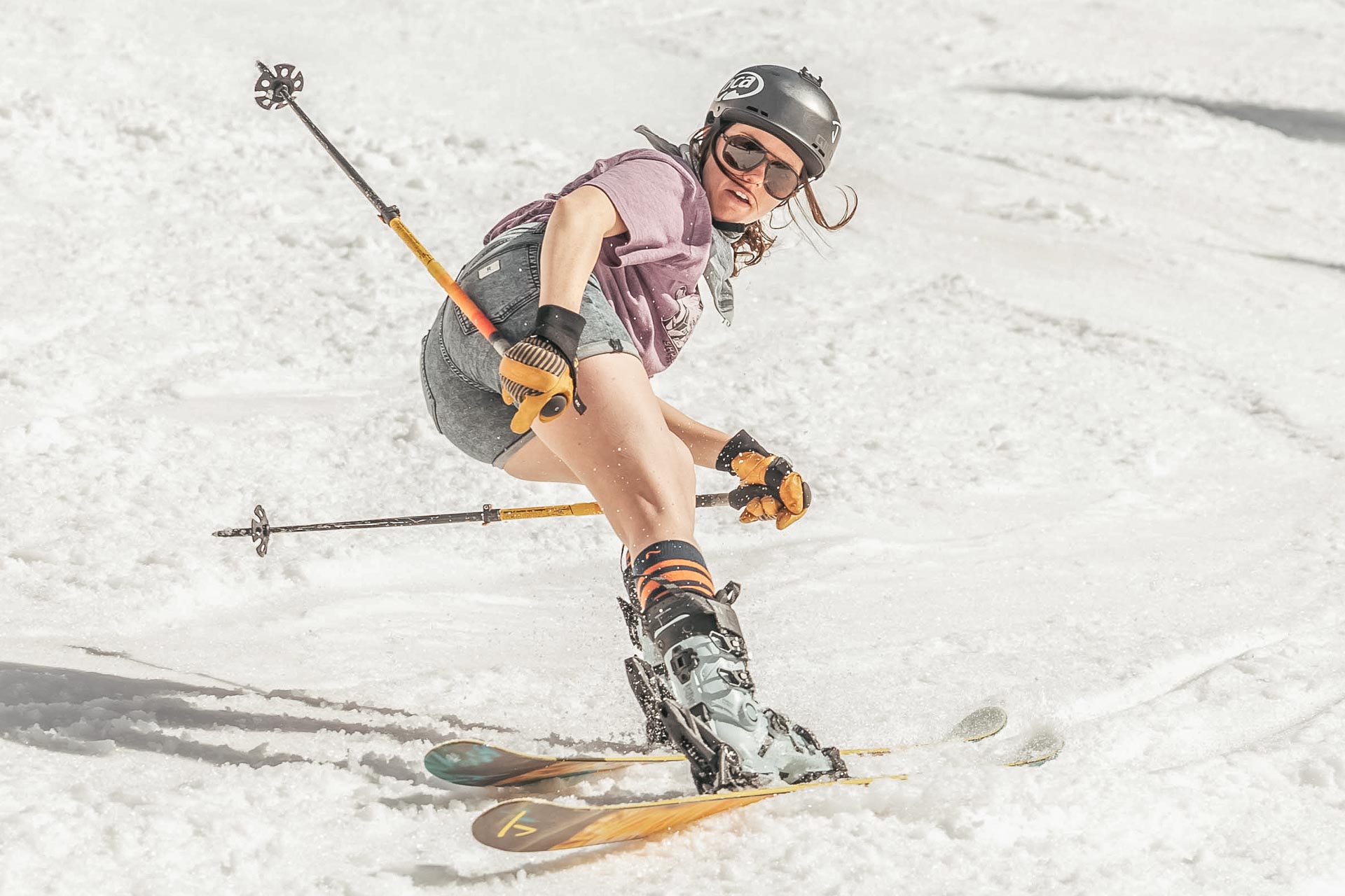 charcoal_brown Woman skiing backwards wearing Ombraz classic armless strap sunglasses