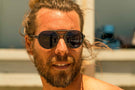 dolomite_tortoise_grey Man smiling wearing Ombraz charcoal dolomite armless strap sunglasses