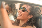 leggero_charcoal_grey Woman sitting in a car smiling wearing Ombraz charcoal leggero armless sunglasses with strap
