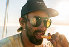 dolomite_tortoise_yellow Close up of man licking chapstick wearing Ombraz unisex dolomite armless string sunglasses