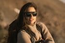 Woman smiling wearing Ombraz classic armless strap sunglasses with side shields