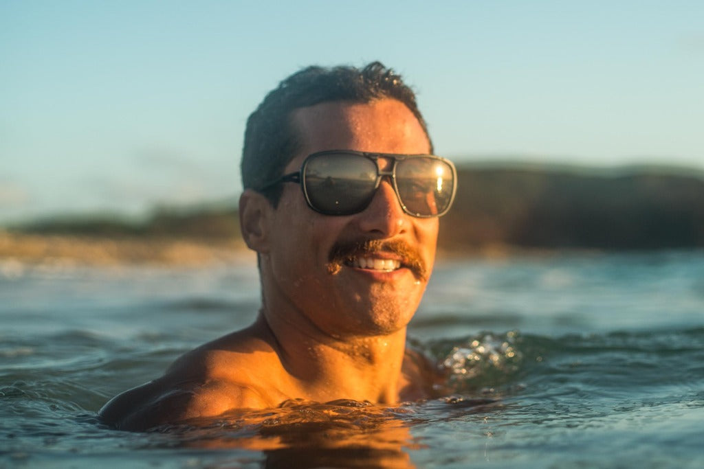 leggero_charcoal_yellow Man with mustache swimming wearing Ombraz leggero armless string sunglasses