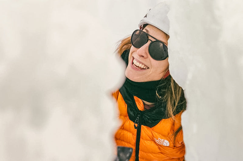 dolomite_charcoal_grey Woman smiling in snow wearing Ombraz dolomite rope sunglasses