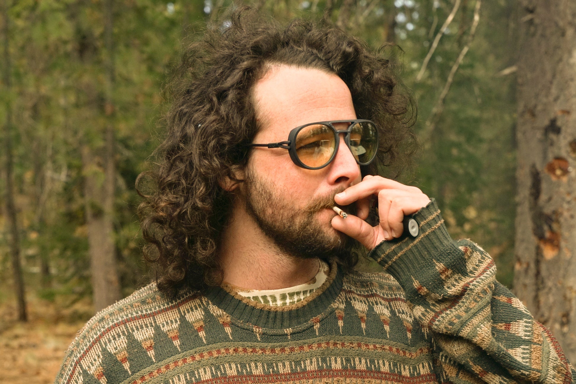 dolomite_tortoise_blocker Man in the forest smoking wearing Ombraz blue blocking armless rope sunglasses