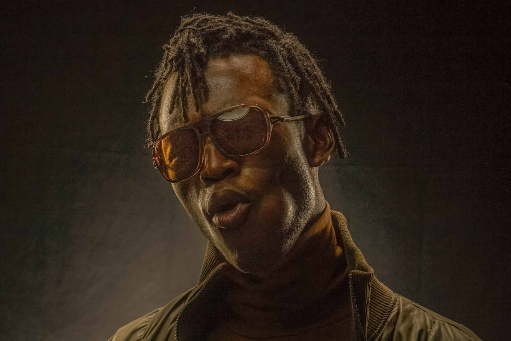ember_yellow Man in the dark wearing Ombraz leggero ember yellow armless sunglasses with strap