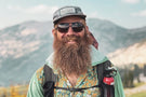 leggero_tortoise_brown Hiker in front of a mountain range wearing Ombraz leggero armless sunglasses with string