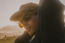 TETON_TORTOISE_BROWN Man adjusting Ombraz teton sunglasses without arms under his hat