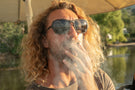 TETON_TORTOISE_GREY Portrait of man smoking wearing Ombraz armless strap sunglasses