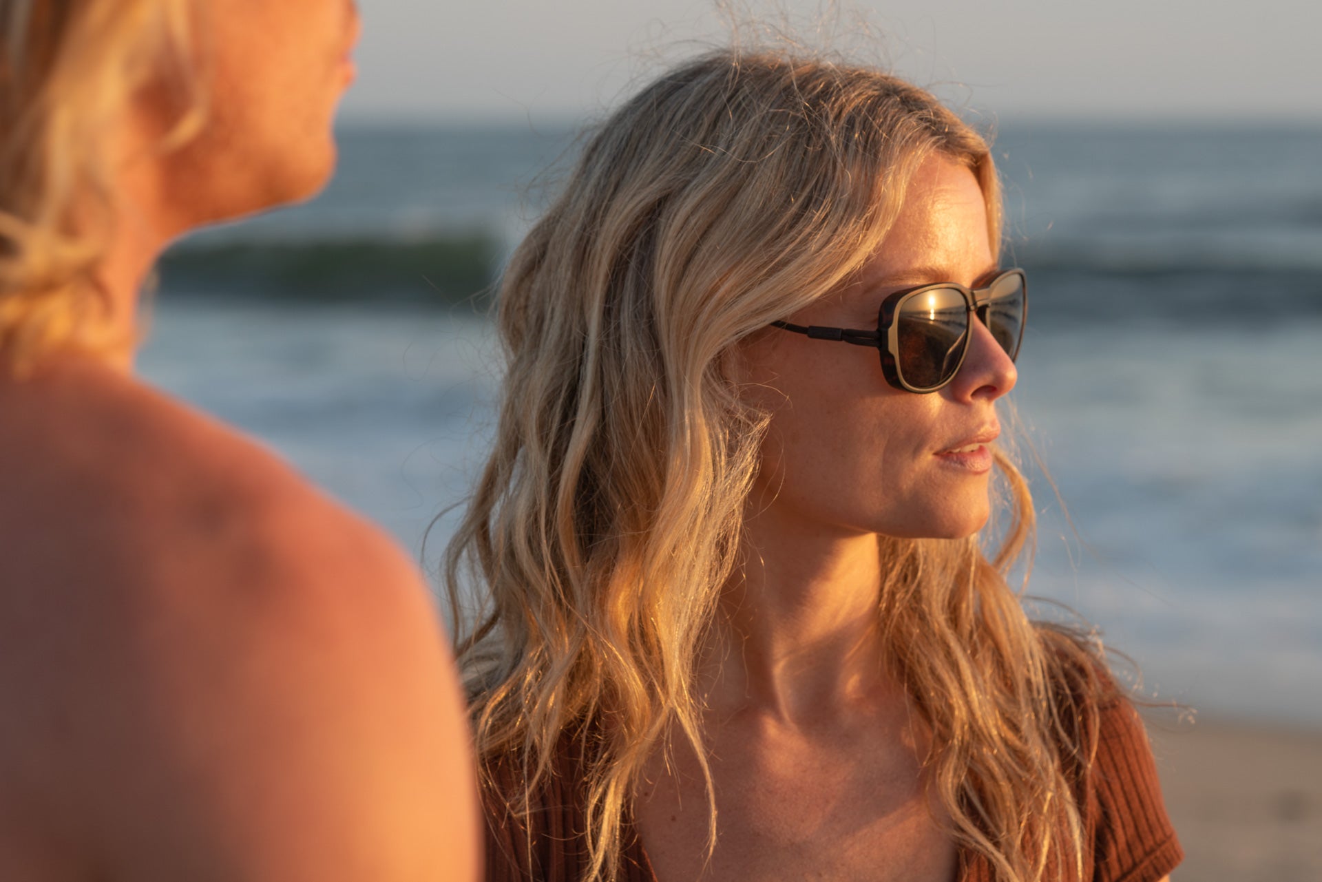 TETON_TORTOISE_YELLOW  Woman on the beach looking into the distance wearing Ombraz teton armless strap sunglasses