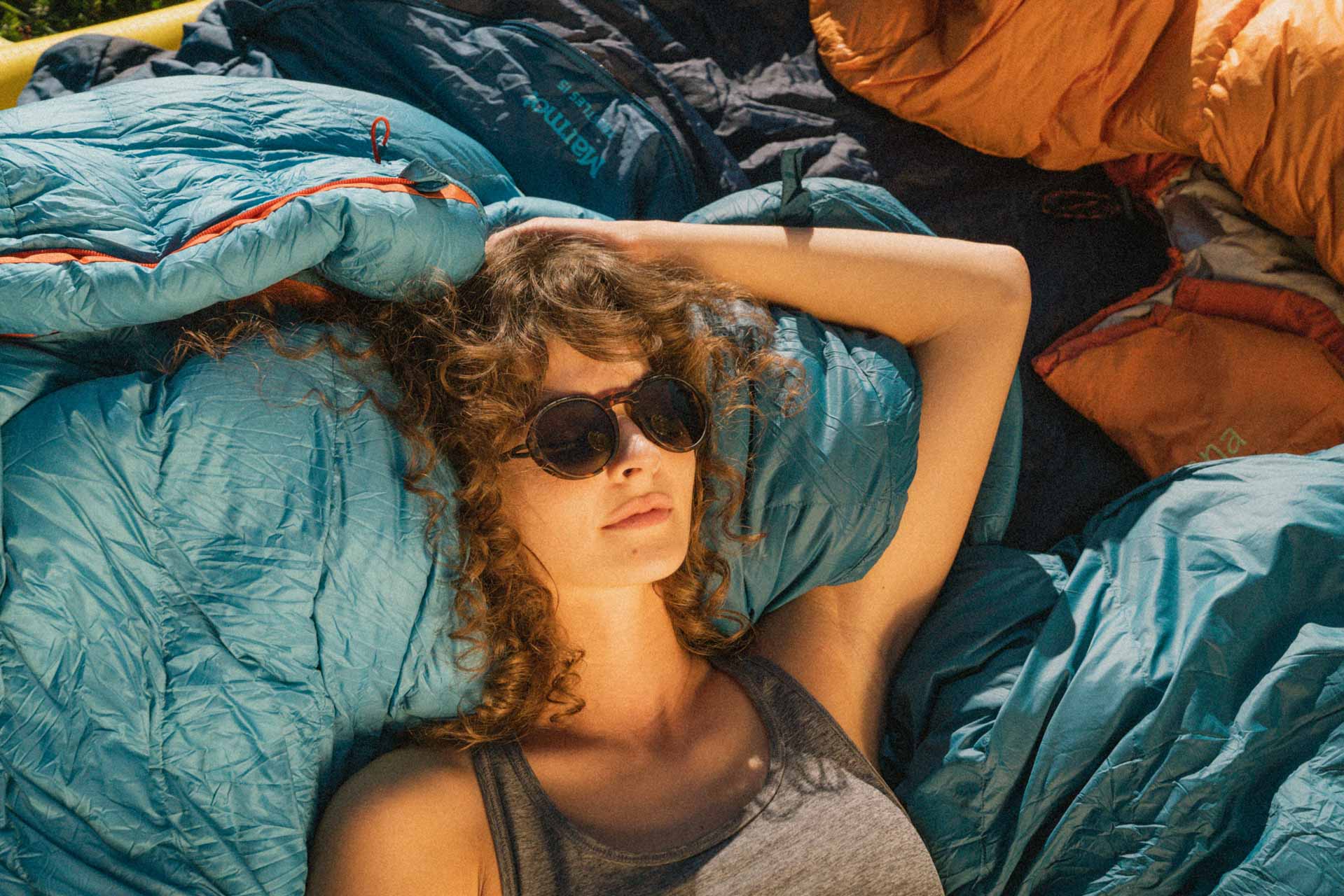 viale_tortoise_grey Woman sleeping on sleeping bag wearing Ombraz viale armless strap sunglasses