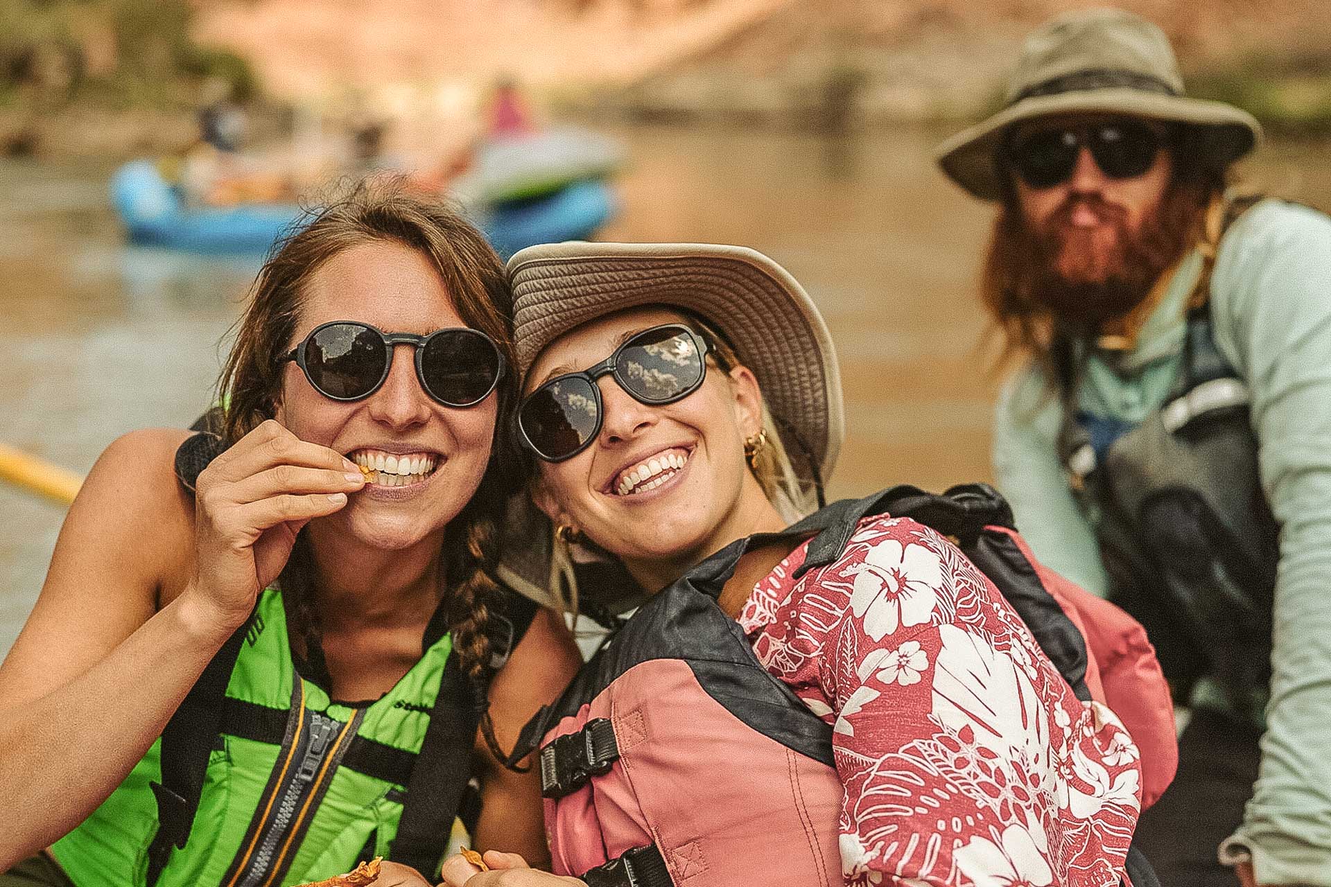 VIALE_CHARCOAL_GREY Two women smiling and rafting wearing Ombraz armless string sunglasses