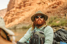 MATTEBROWN_GREY Man rafting a river staring wearing Ombraz unisex armless strap sunglasses